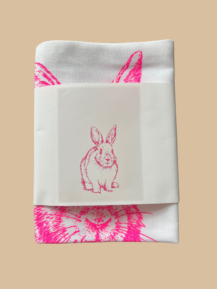Geschirrtuch "Hase sitzend" in Neon-Pink auf weißem Hintergrund von 17;30 Hamburg in einer Banderole eingewickelt