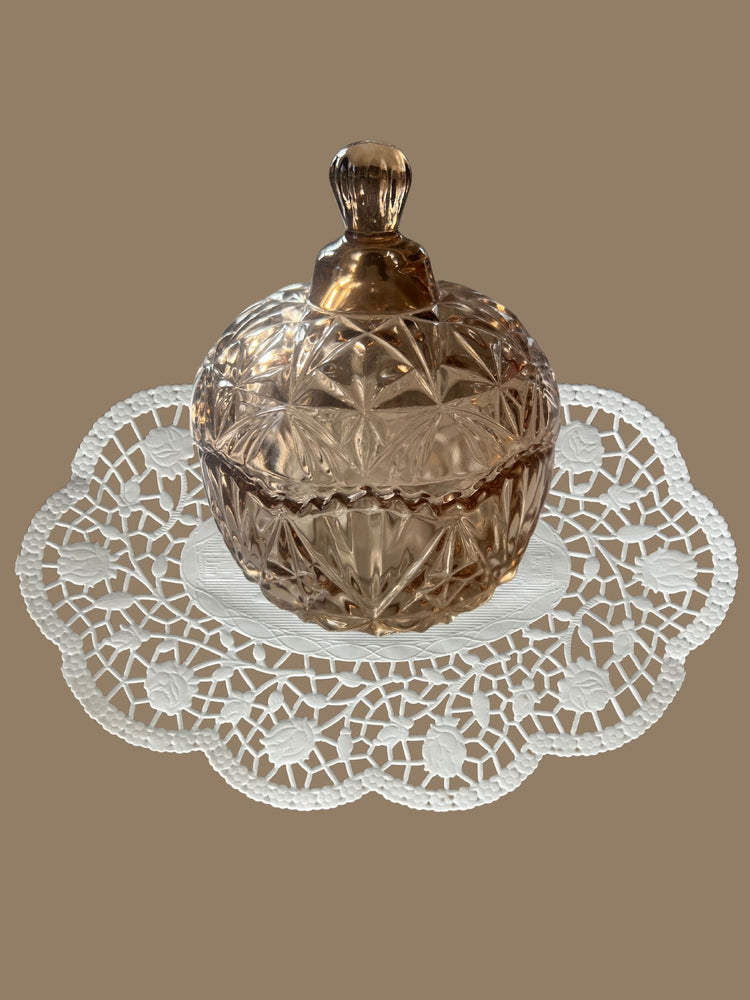 Bonbonniere mit Deckel aus Kristallglas in Hellbraun auf einem Vintage Deckchen abgebildet - klassisch und zeitlose Eleganz