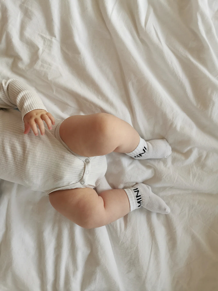 Tennissocken für Babys mit dem schlichten, schwarzen Statement "MINI"
