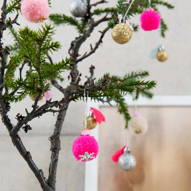 Pompon- und Kugel-Anhänger von Rico Design am Tannenbaumzweig