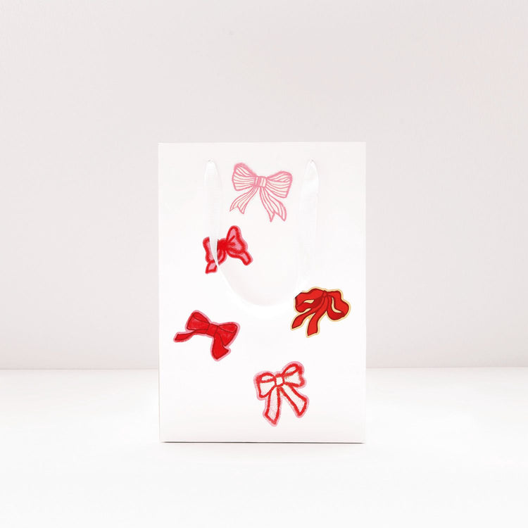 Sticker in Schleifenform in verschiedenen Farben von Rico Design verzieren eine Geschenktüte