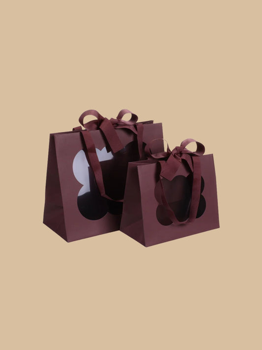 Geschenktüte in Bordeaux mit dekorativem Fenster und Schleife in klein & groß abgebildet