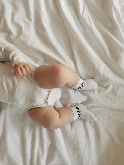Tennissocken für Babys mit dem schlichten, schwarzen Statement "MINI"